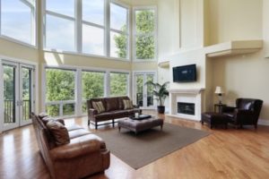 Large wall of beautiful vinyl windows allowing sunlight to flood a modernly designed family room