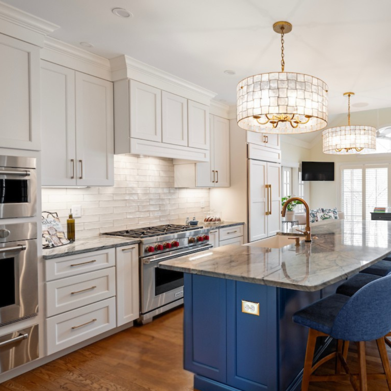 Bright and modern kitchen with white cabinets, blue island, stainless steel appliances, and hardwood floors in a Lexington, Kentucky home.