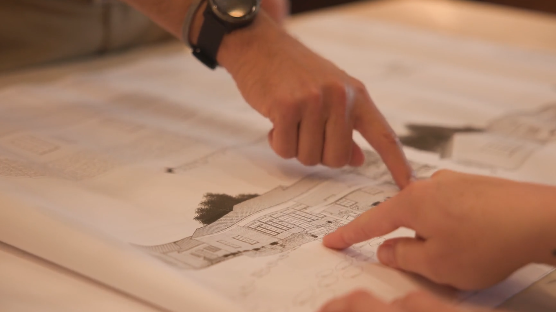 BACK Construction employee-owners collaborating on architectural plans for a remodeling project