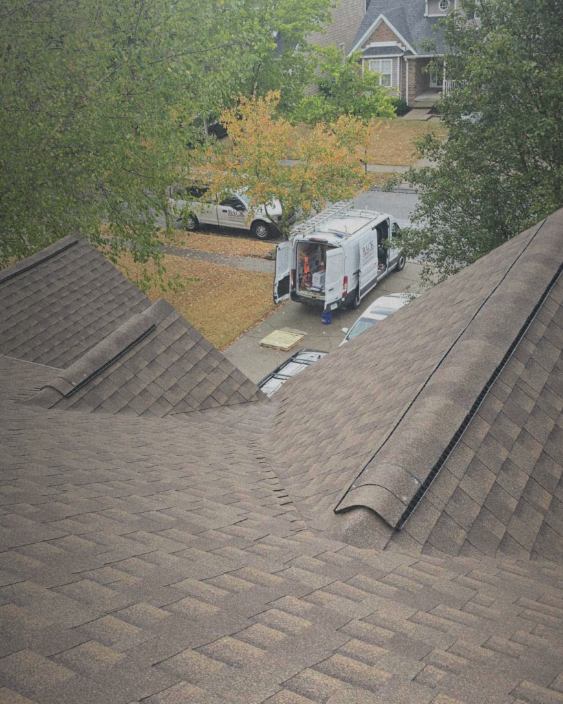 Residential roofing project in progress in Lexington, KY by BACK Construction, featuring shingle installation and company trucks on-site
